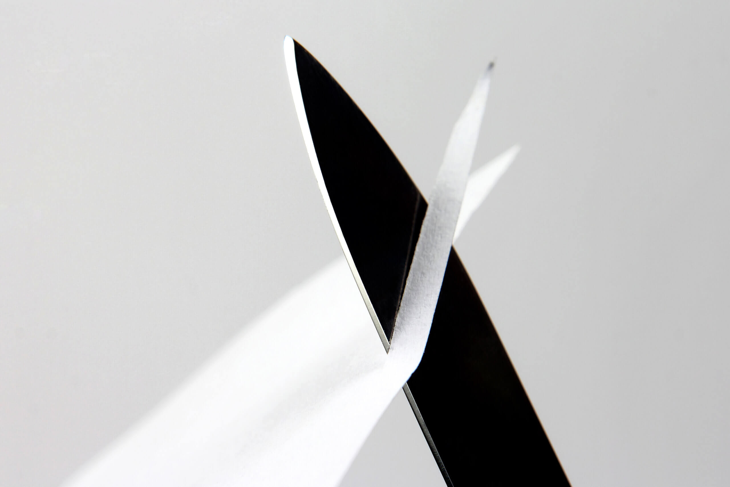 blade of a sharp knife cut across the white paper